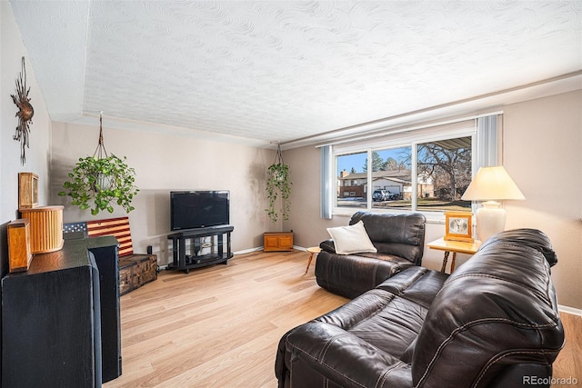 living room featuring light wood-type flooring and a textured ceiling