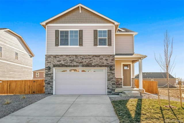 craftsman-style house featuring stone siding, an attached garage, driveway, and fence