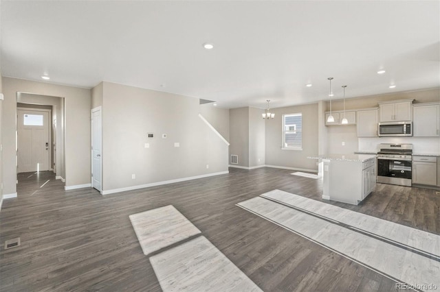 kitchen featuring stainless steel appliances, baseboards, dark wood-type flooring, and visible vents