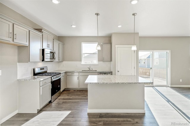 kitchen featuring light stone counters, tasteful backsplash, appliances with stainless steel finishes, and a sink