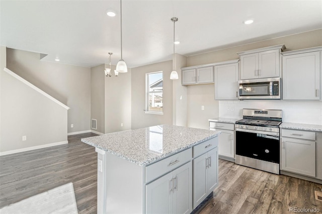 kitchen with decorative backsplash, appliances with stainless steel finishes, a center island, and light wood finished floors