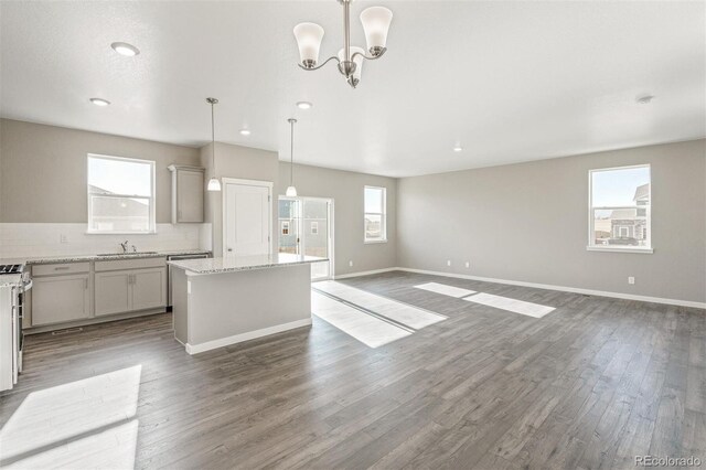 kitchen with backsplash, wood finished floors, a wealth of natural light, and a kitchen island