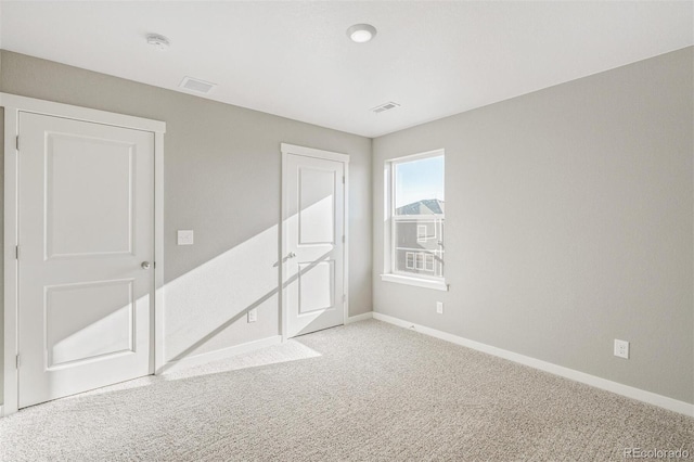 spare room featuring visible vents, baseboards, and carpet flooring