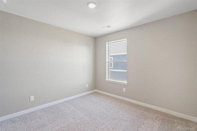 unfurnished room with visible vents, baseboards, and light colored carpet