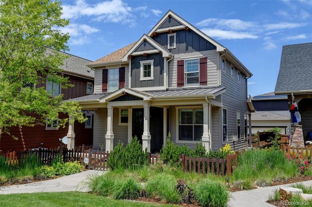 5080 Uinta St, Denver, CO 80238 - craftsman house featuring board and batten siding, covered porch, a fenced front yard, and a standing seam roof