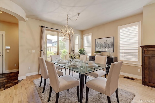 5080 Uinta St, Denver, CO 80238 - dining area featuring a chandelier, light wood-type flooring, and arched walkways