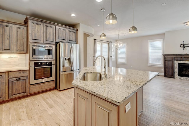 5080 Uinta St, Denver, CO 80238 - kitchen featuring stainless steel appliances, recessed lighting, light wood-type flooring, an island with sink, and plenty of natural light