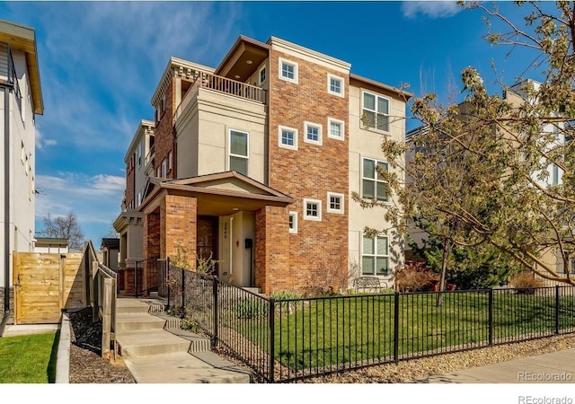 view of front of property with a balcony and a front lawn