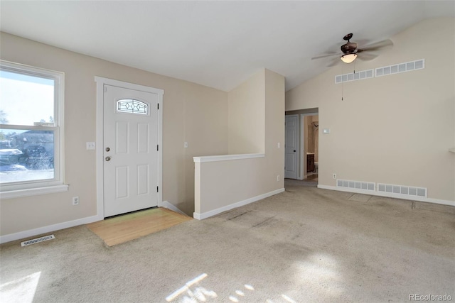 foyer with ceiling fan, light colored carpet, and lofted ceiling