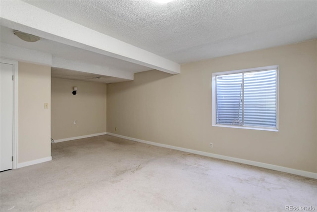 basement featuring light carpet and a textured ceiling