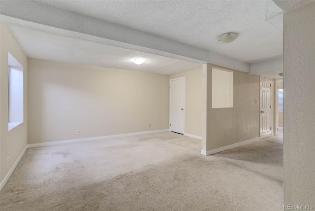 empty room with a textured ceiling and light colored carpet