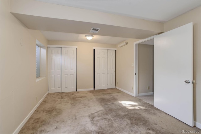 unfurnished bedroom with light carpet and two closets