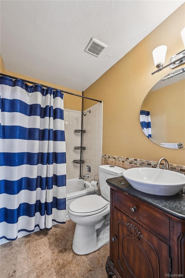 full bathroom with a textured ceiling, visible vents, shower / bath combo, vanity, and toilet