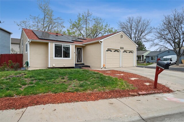 646 S Joplin St, Aurora, CO 80017 - view of front of property featuring a garage, roof mounted solar panels, driveway, and roof with shingles
