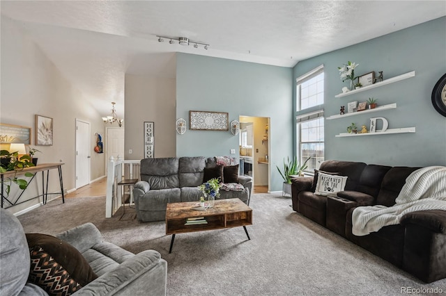 646 S Joplin St, Aurora, CO 80017 - carpeted living area featuring a chandelier, a towering ceiling, and track lighting