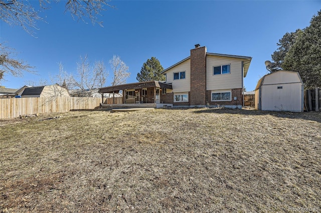 rear view of property featuring a storage unit, brick siding, an outdoor structure, and fence