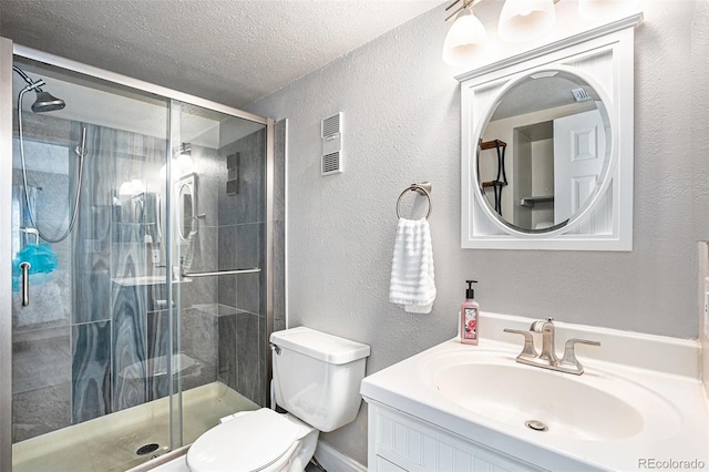 bathroom featuring a shower with door, vanity, a textured ceiling, and toilet