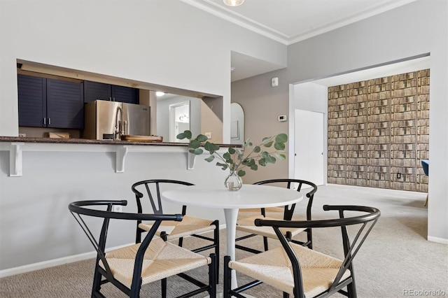 carpeted dining area featuring baseboards and ornamental molding