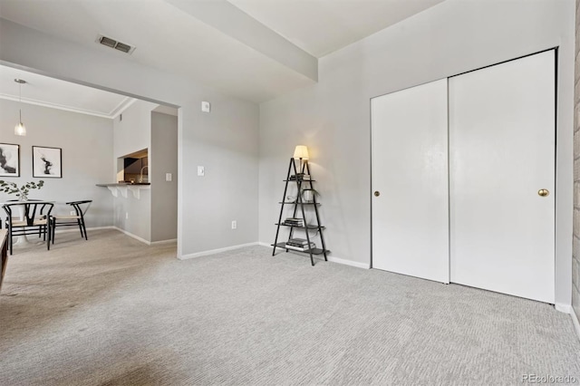 interior space with visible vents, carpet flooring, crown molding, and baseboards