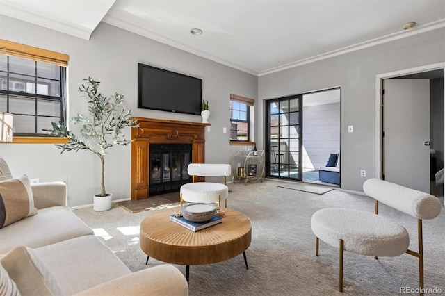 carpeted living room featuring a glass covered fireplace, baseboards, and ornamental molding