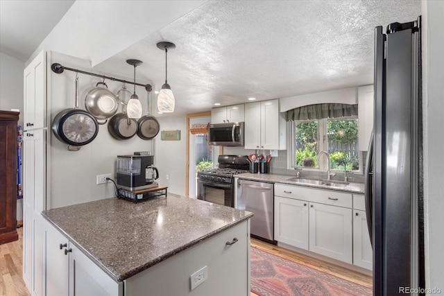 225 Shavano St, Poncha Springs, CO 81242 - kitchen with appliances with stainless steel finishes, light wood finished floors, a textured ceiling, and white cabinets