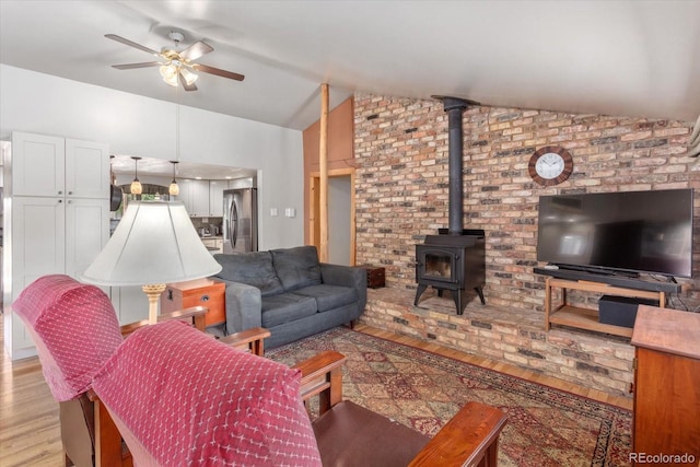 225 Shavano St, Poncha Springs, CO 81242 - living room with light wood-style floors, lofted ceiling, a ceiling fan, and a wood stove