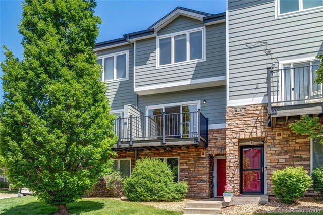 2763 W Riverwalk Cir Unit B, Littleton, CO 80123 - view of front of home with a balcony and stone siding