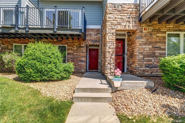 2763 W Riverwalk Cir Unit B, Littleton, CO 80123 - doorway to property featuring a balcony and stone siding