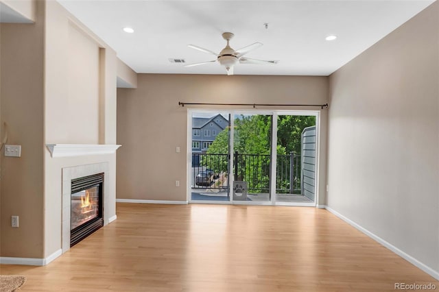 2763 W Riverwalk Cir Unit B, Littleton, CO 80123 - unfurnished living room with light wood finished floors, ceiling fan, baseboards, a fireplace, and recessed lighting