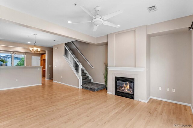 2763 W Riverwalk Cir Unit B, Littleton, CO 80123 - unfurnished living room with a tiled fireplace, light wood-type flooring, baseboards, a ceiling fan, and recessed lighting