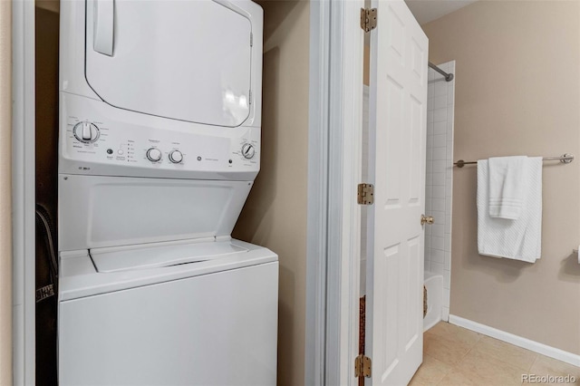2763 W Riverwalk Cir Unit B, Littleton, CO 80123 - washroom with estacked washer and dryer, baseboards, and light tile patterned floors
