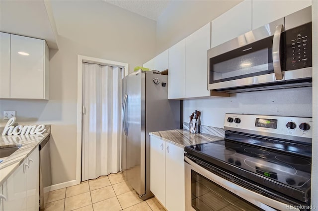 4274 S Salida Way Unit 11, Aurora, CO 80013 - kitchen featuring white cabinetry, light tile patterned floors, a textured ceiling, light stone countertops, and appliances with stainless steel finishes