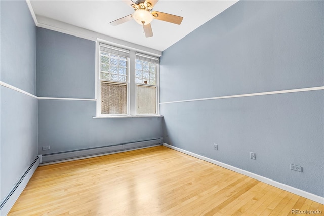 spare room with a baseboard heating unit, ceiling fan, light wood finished floors, and baseboards