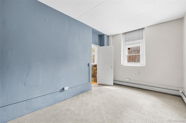 spare room with a baseboard heating unit and a textured wall