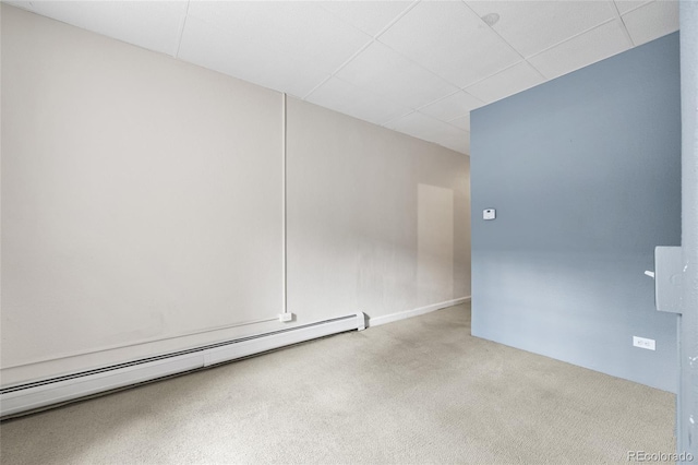 empty room with light carpet, baseboard heating, and a paneled ceiling