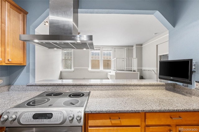 kitchen featuring light stone countertops, brown cabinets, island range hood, and stainless steel electric stove