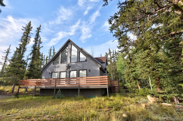 rear view of property featuring a wooden deck