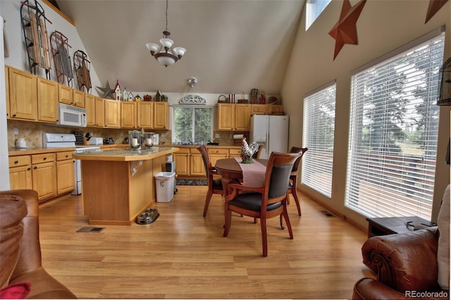 kitchen with light countertops, white appliances, light wood-style floors, and an inviting chandelier