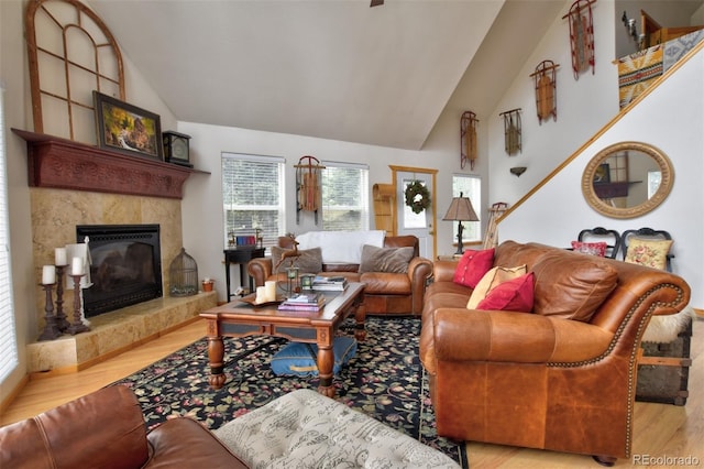 living room featuring high vaulted ceiling, wood finished floors, and a high end fireplace