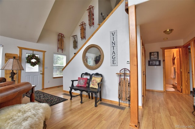 entrance foyer with a high ceiling, light wood-style flooring, and baseboards