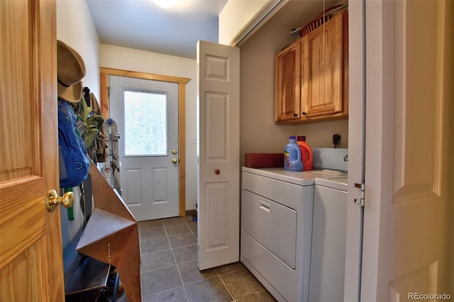 laundry area with cabinet space, dark tile patterned floors, and washing machine and clothes dryer