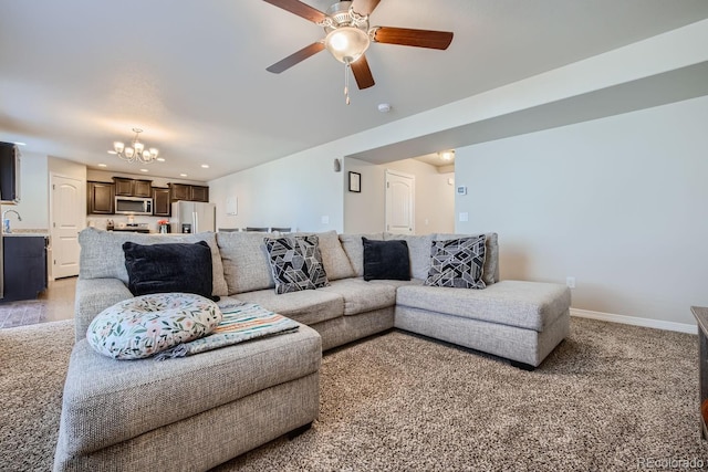 living room with carpet and ceiling fan with notable chandelier