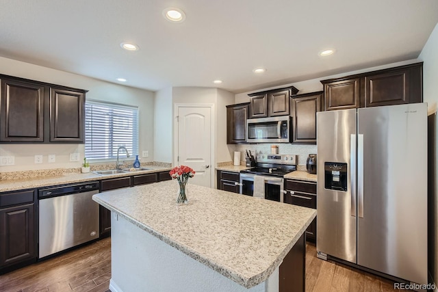 kitchen with sink, a center island, dark wood-type flooring, and stainless steel appliances