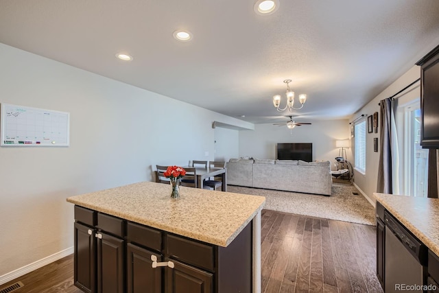 kitchen featuring dark hardwood / wood-style flooring, dishwasher, ceiling fan with notable chandelier, dark brown cabinetry, and a center island