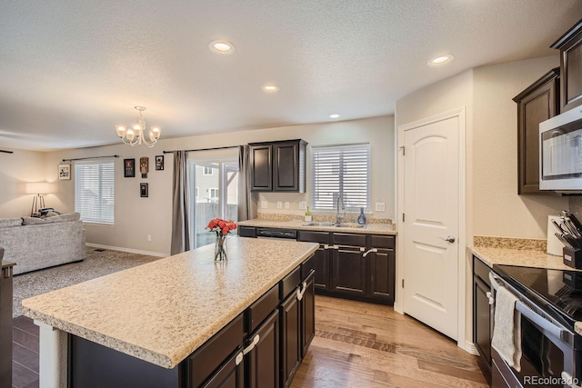 kitchen featuring a kitchen island, light hardwood / wood-style flooring, stainless steel appliances, and plenty of natural light