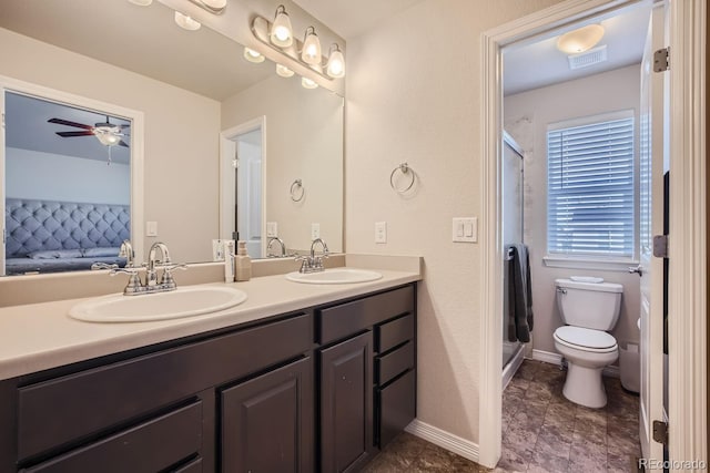 bathroom featuring vanity, toilet, a shower with door, and ceiling fan