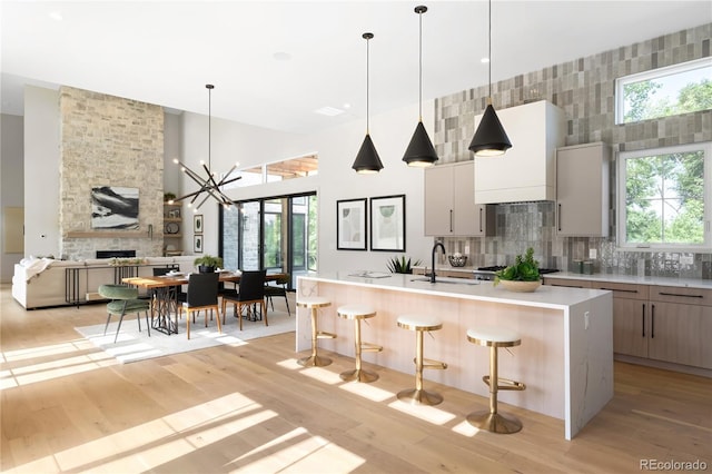 5070 Easley Rd, Golden, CO 80403 - kitchen with modern cabinets, a breakfast bar, light wood-type flooring, and a towering ceiling
