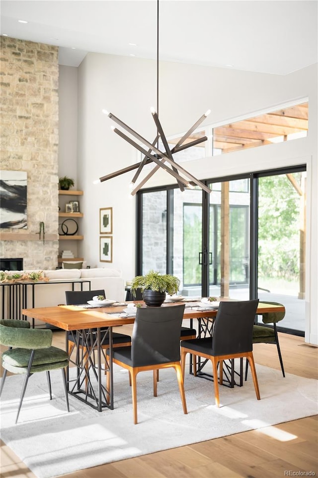 5070 Easley Rd, Golden, CO 80403 - dining room with light wood finished floors, a towering ceiling, a fireplace, recessed lighting, and a chandelier