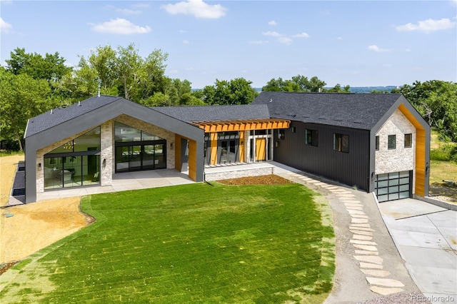 5070 Easley Rd, Golden, CO 80403 - rear view of house with a yard, a garage, concrete driveway, and a patio area