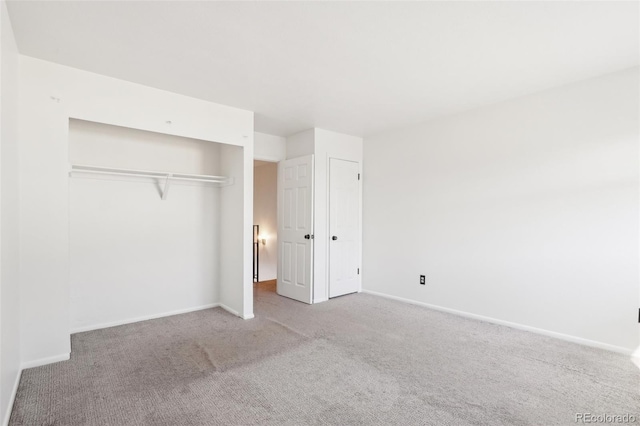 unfurnished bedroom featuring carpet flooring, baseboards, and a closet
